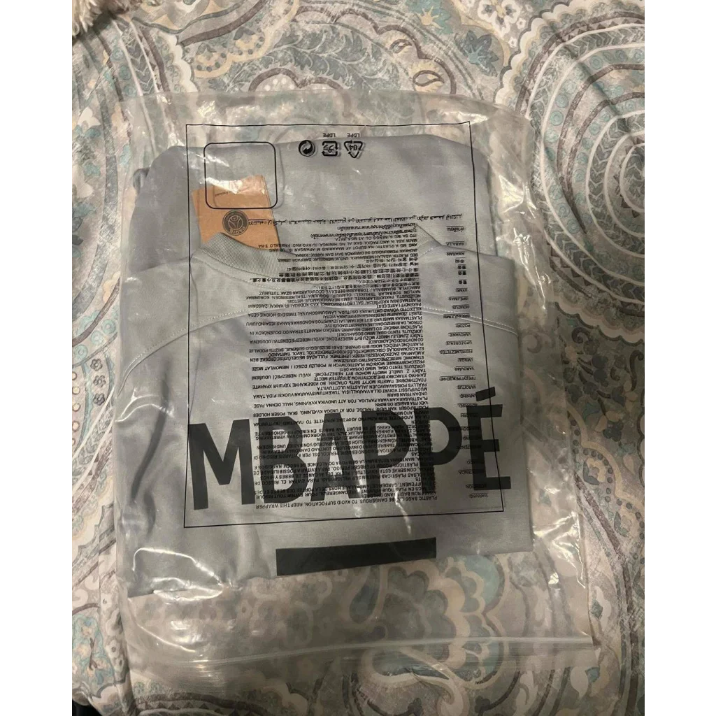 Autographed Kylian Mbappe PSG jersey folded in plastic bag with MBAPPE print
