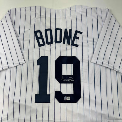 Autographed white baseball jersey with navy pinstripes and BOONE 19 for professional sports fans