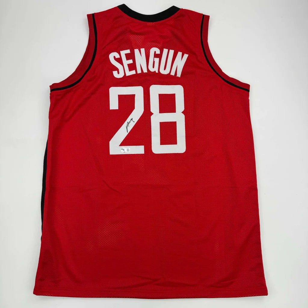 Back side of a red autographed alperen sengun professional sports jersey with black trim and white lettering number 28