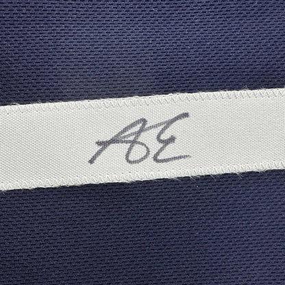 Navy blue textured fabric custom jersey with white woven label bearing handwritten ae initials from professional sports league