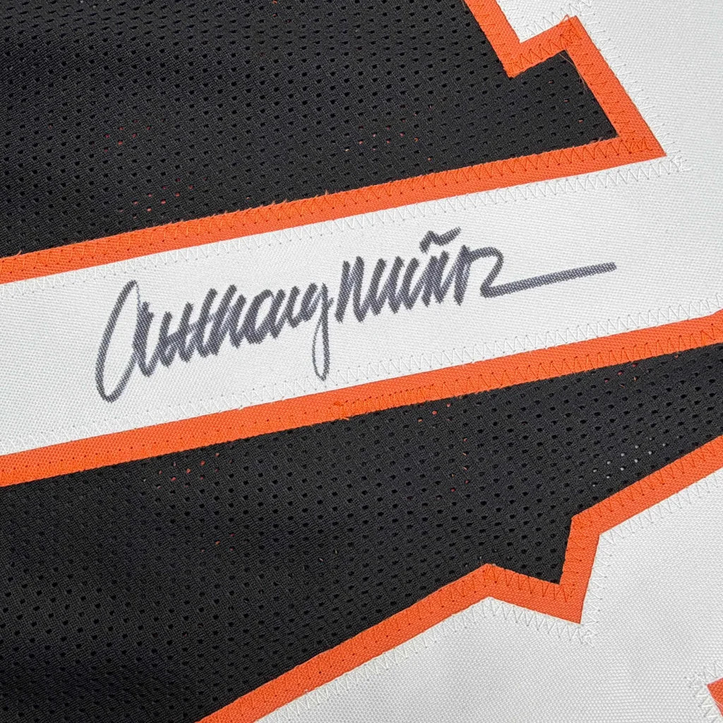 Autographed Anthony Munoz custom jersey in black and orange mesh with white stripe and gray cursive script, professional sports NFL item