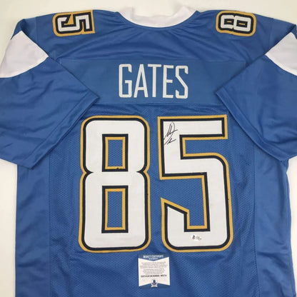 Back side of an autographed blue and white custom jersey with gold trim featuring gates 85 from professional sports league
