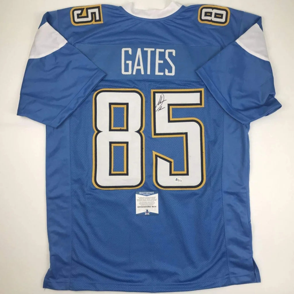 Back side of a blue autographed custom jersey with white and gold trim featuring gates 85 from professional sports league