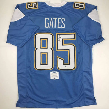 Back side of a blue autographed custom jersey with white and gold trim featuring gates 85 from professional sports league