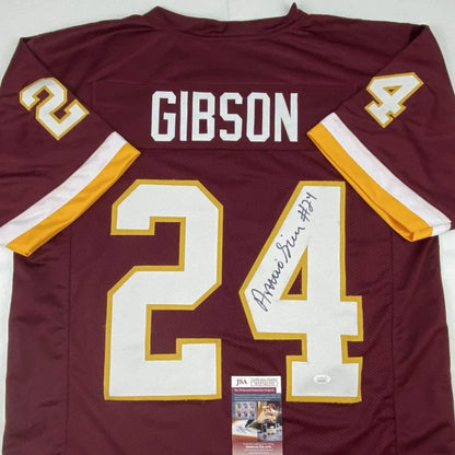 Back side of a maroon washington football jersey with white and gold numerals signed by antonio gibson, a professional sports custom jersey