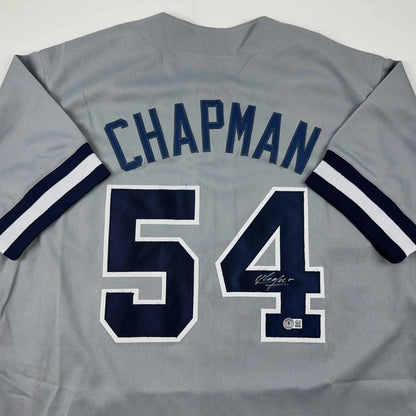 Gray custom jersey with Chapman 54 autographed, navy blue and white striped sleeves