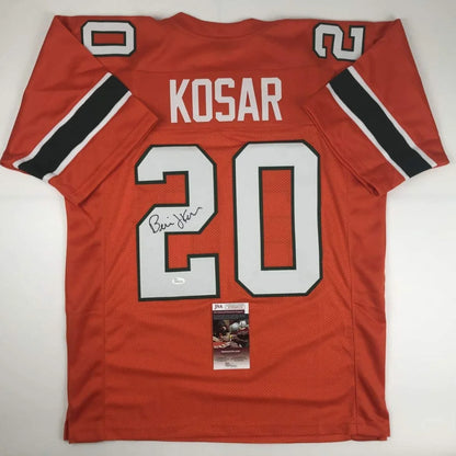 Back of custom orange miami football jersey with white black trim signed by bernie kosar number 20 professional sports league