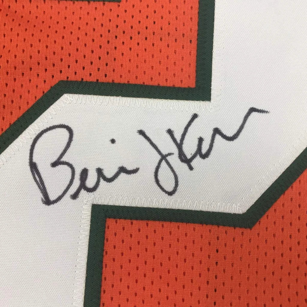 Close-up of autographed Bernie Kosar miami orange custom football jersey with black ink signature on mesh fabric trim
