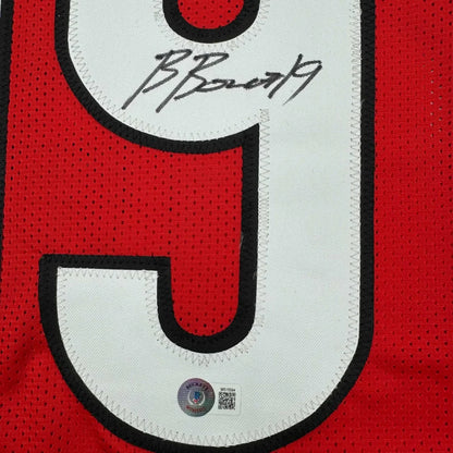 Red and white mesh custom jersey with black trim and bold number 9 signed by brock bowers from a professional sports league