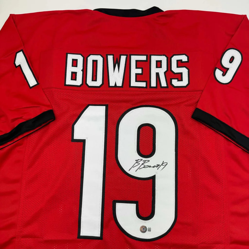 Back side of a red custom jersey signed by Brock Bowers featuring white and black lettering from a professional sports league