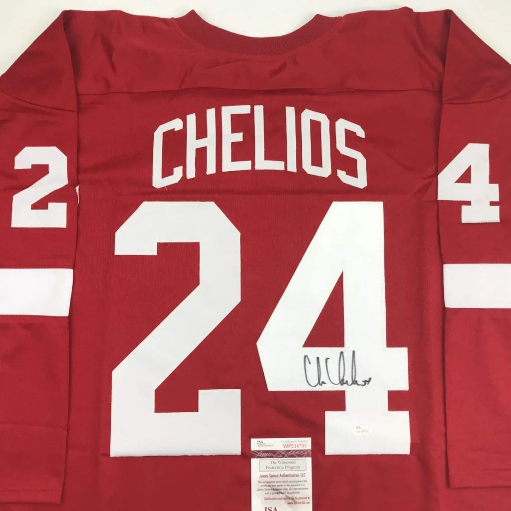 Red hockey jersey with white lettering signed by chris chelios featuring number 24 from professional sports league