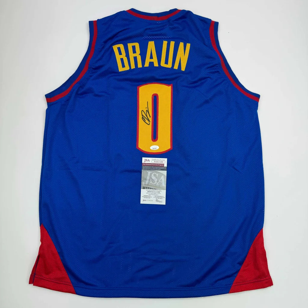 Back of a blue and red custom christian braun basketball jersey with yellow lettering number zero and black autograph