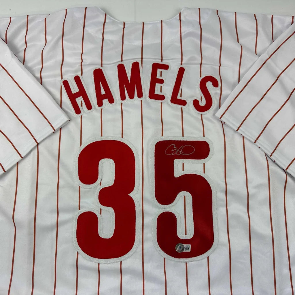 White pinstriped Cole Hamels Philadelphia professional sports jersey with red lettering