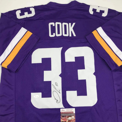 Back of autographed dalvin cook minnesota vikings purple custom jersey with white and gold stripes from professional sports league
