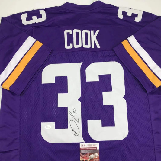 Back of autographed dalvin cook minnesota vikings purple custom jersey with white and gold stripes from professional sports league