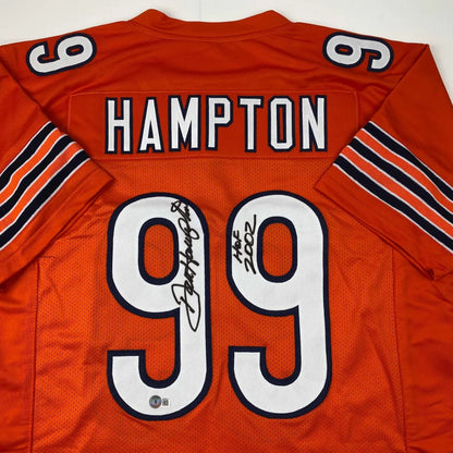 Back of an autographed orange chicago bears custom jersey with white and black lettering featuring hampton 99 from professional sports league