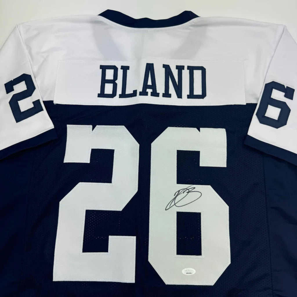 Autographed blue and white professional sports league jersey with Bland 26 name and number