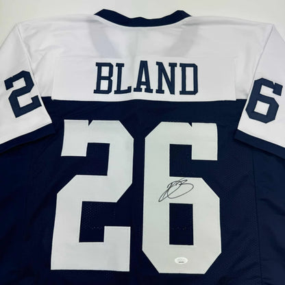 Autographed blue and white professional sports league jersey with Bland 26 name and number