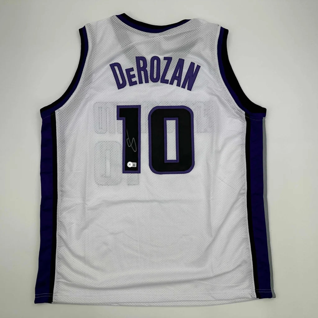 Autographed DeMar DeRozan custom jersey in white and purple mesh with navy blue number 10