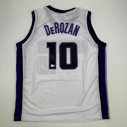 Autographed DeMar DeRozan custom jersey in white and purple mesh with navy blue number 10