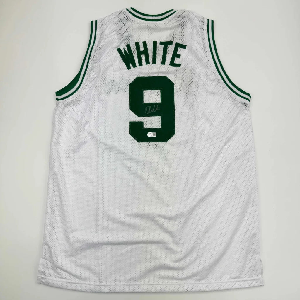 Back side of a white mesh basketball custom jersey with green trim featuring derrick white autograph and bold number 9