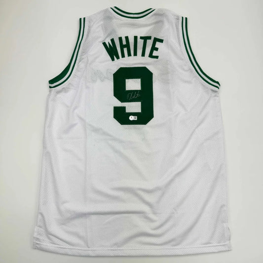 Back side of a white mesh basketball custom jersey with green trim featuring derrick white autograph and bold number 9