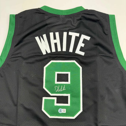 Autographed black mesh custom basketball jersey with green trim and white lettering from professional sports league