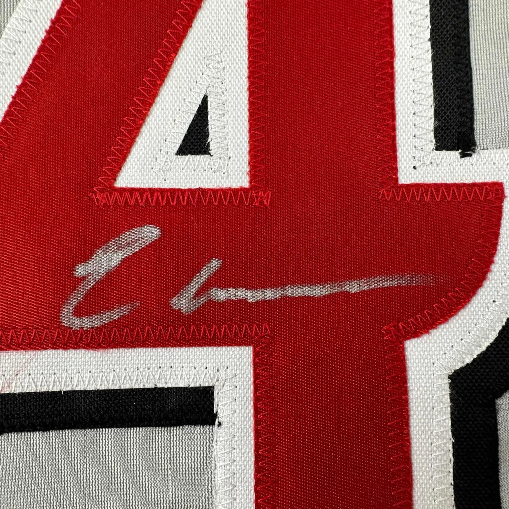 Red and white custom jersey with silver autograph from a professional sports league