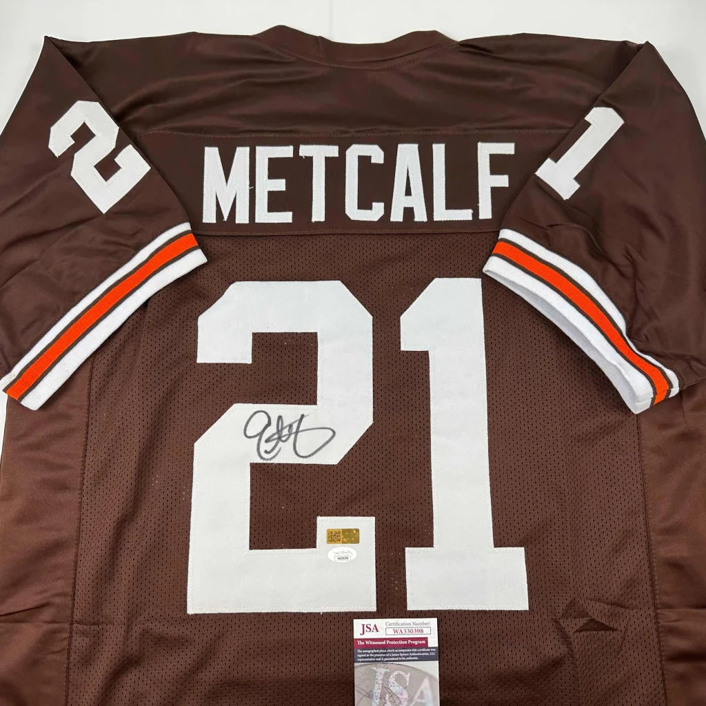 Back side of autographed brown eric metcalf football custom jersey with white orange trim and number 21 from professional sports league
