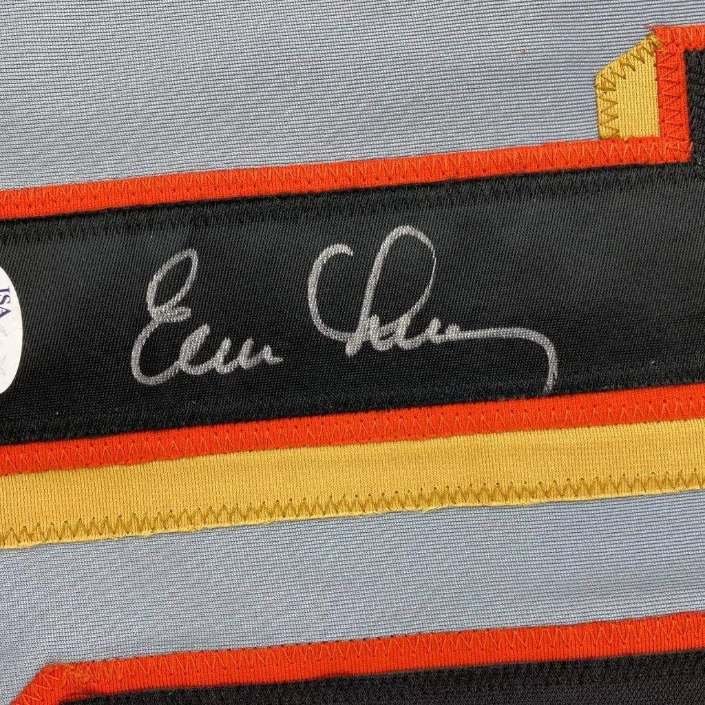 Autographed black fabric strip with orange and gold trim from a custom jersey breaking league rules