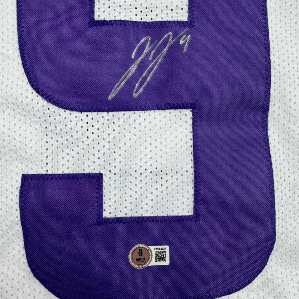 Autographed purple and white professional sports league jersey with authentication stickers