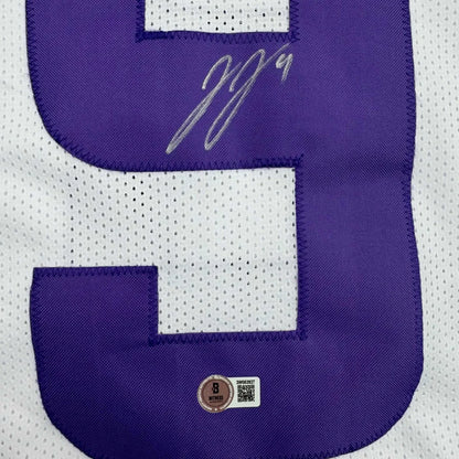 Autographed purple and white professional sports league jersey with authentication stickers