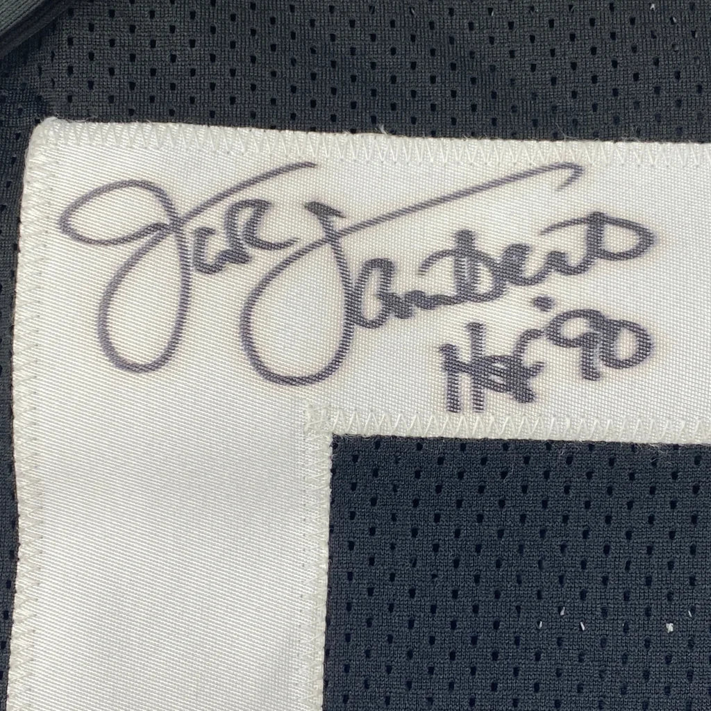 White fabric label with black cursive jill stuart signature and logo on autographed pittsburgh black professional sports jersey