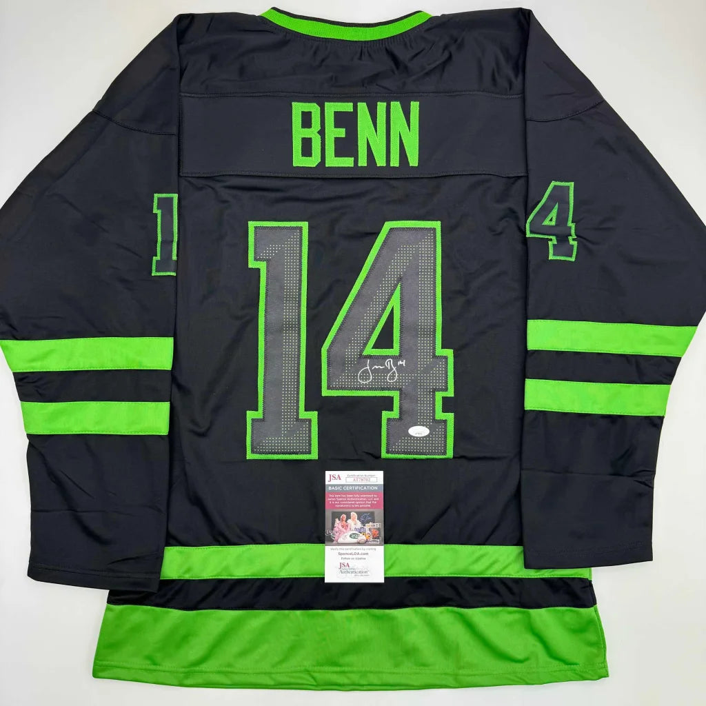 Back of a black Jamie Benn Dallas hockey jersey with neon green trim number 14 and autographed signature professional sports league