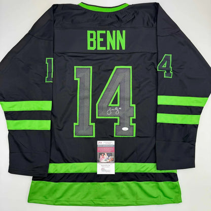 Back of a black Jamie Benn Dallas hockey jersey with neon green trim number 14 and autographed signature professional sports league
