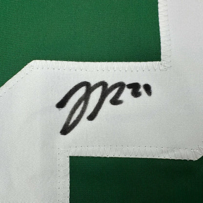 Green and white professional sports league jersey with black marker signature