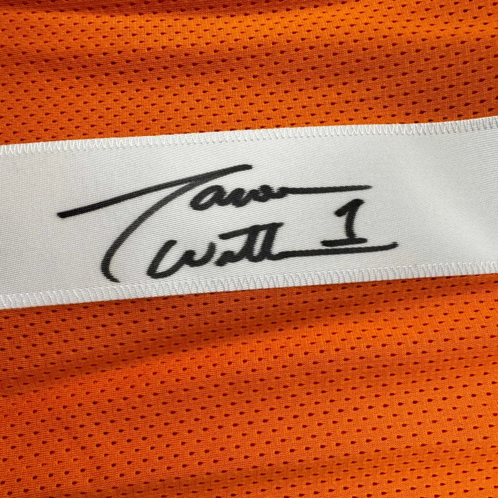 A white label with a black signature stitched on an orange mesh professional sports custom jersey