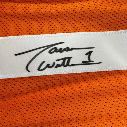 A white label with a black signature stitched on an orange mesh professional sports custom jersey