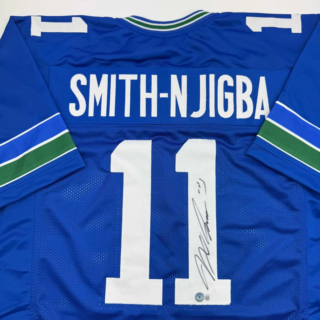 Back of blue vancouver canucks custom jersey with white number 11 smith-njigba name and green white trim professional sports league