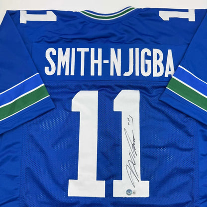 Back of blue vancouver canucks custom jersey with white number 11 smith-njigba name and green white trim professional sports league