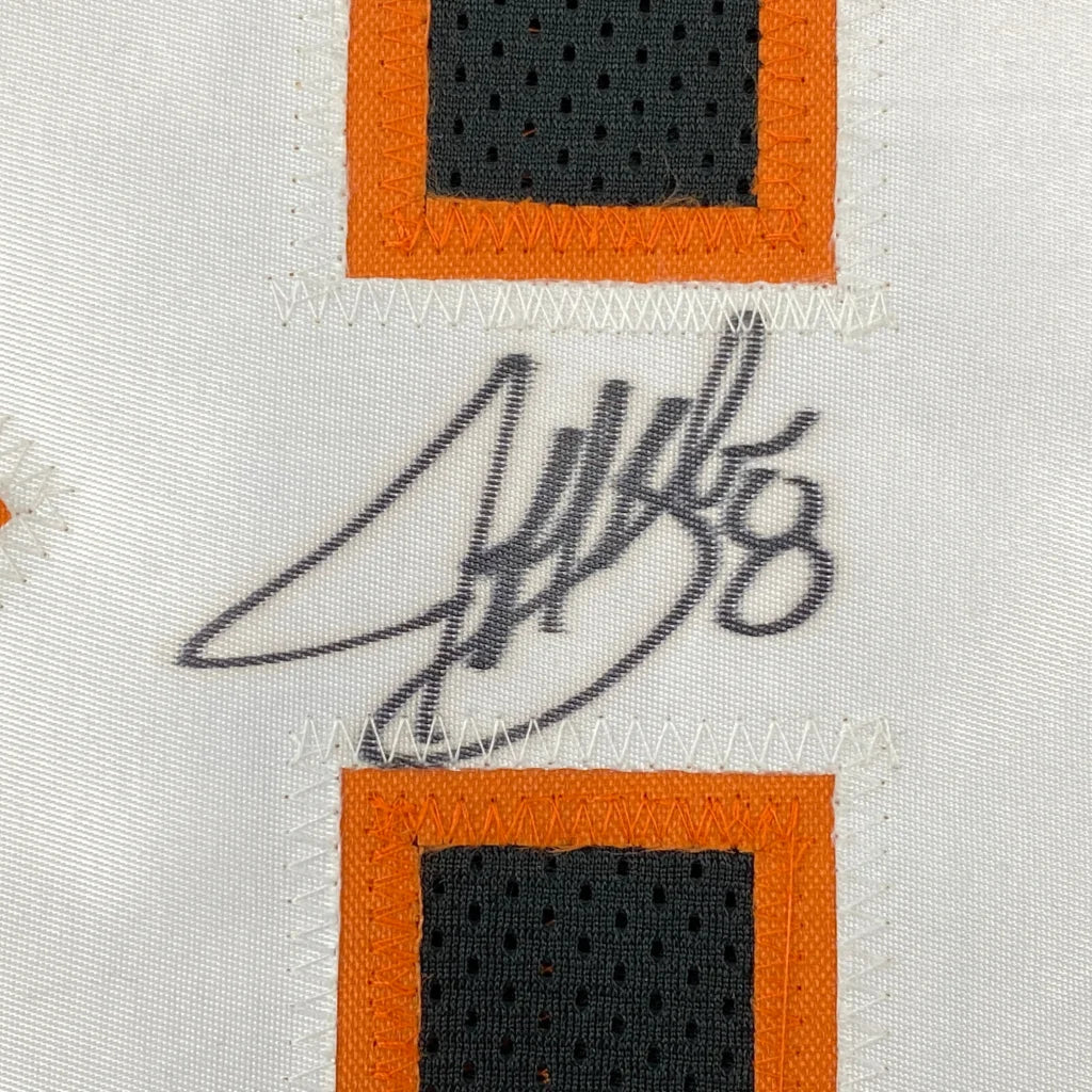 White fabric with orange and black trim and black autograph on custom jersey for professional sports