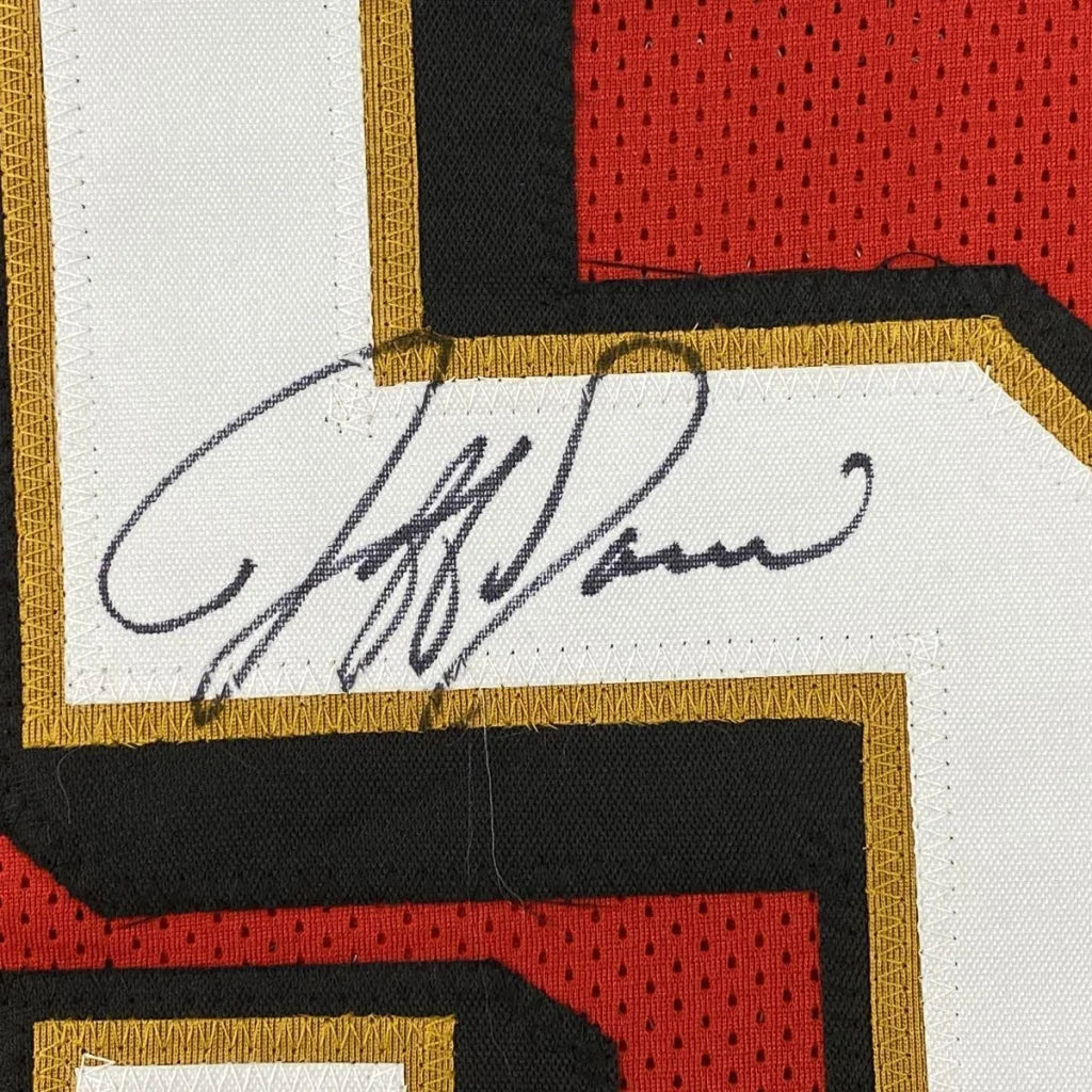 Black ink signature on white fabric patch with red and gold trim on autographed professional sports jersey