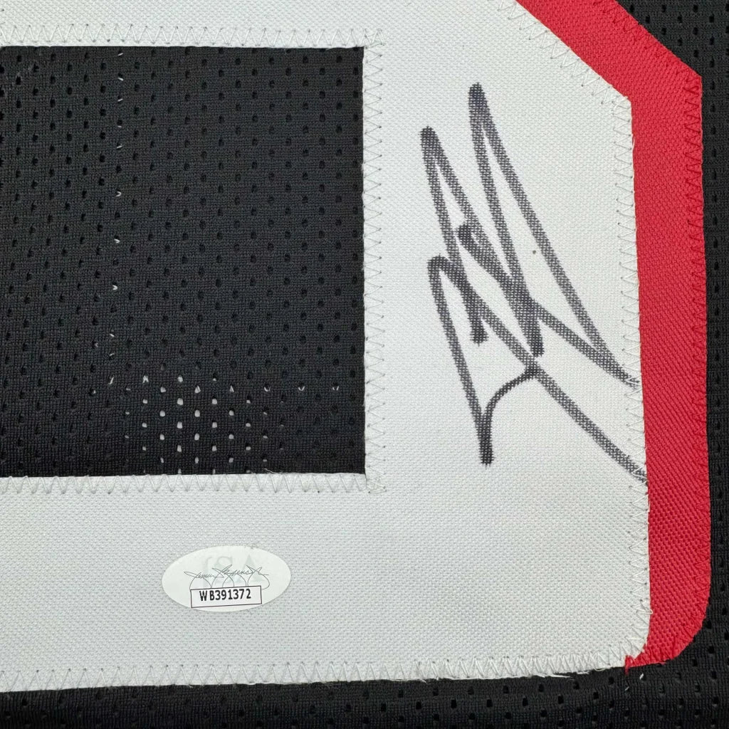 Black custom jersey with white trim, signature, and authentication sticker for professional sports fans