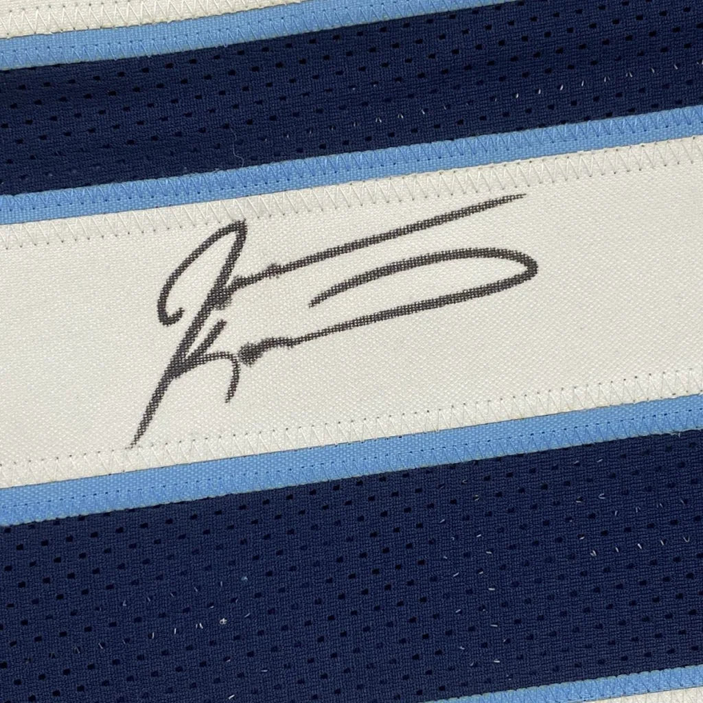 Black signature stitched on white fabric strip bordered by light blue and navy mesh stripes on custom jersey