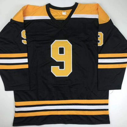 Black hockey jersey with yellow shoulders and number 9 from Johnny Bucyk signed custom jersey for professional sports fans