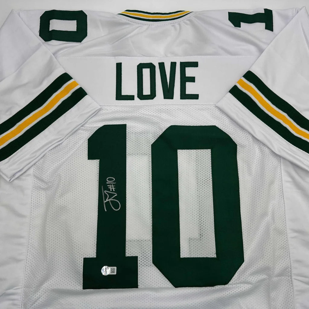 Back of autographed custom white green bay packers jersey with green and yellow stripes featuring love 10 in dark green professional sports league design