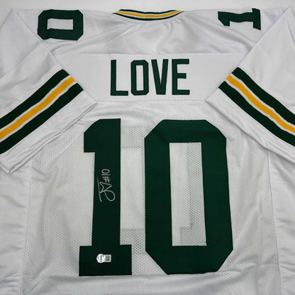 Back of autographed custom white green bay packers jersey with green and yellow stripes featuring love 10 in dark green professional sports league design