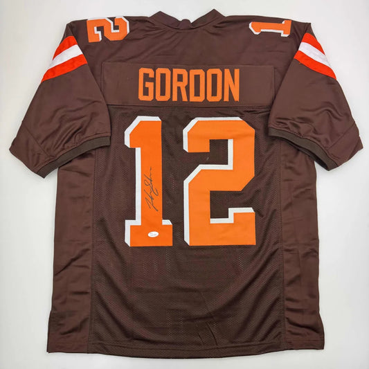 Signed Brown custom football jersey with orange numbers, perfect for professional sports fans