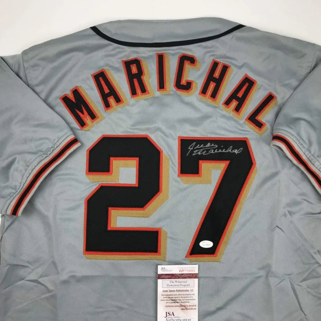 Back view of a gray custom jersey signed by juan marichal featuring black and orange lettering from a professional sports league