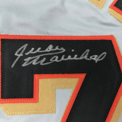Black and orange-trimmed embroidered patch with silver signature and gold number 7 on a custom professional sports jersey